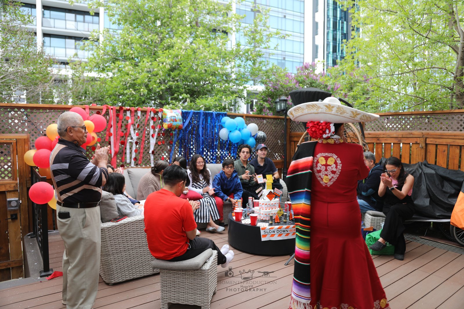 Mariachi performer entertaining guests at a family backyard party with balloons and streamers.