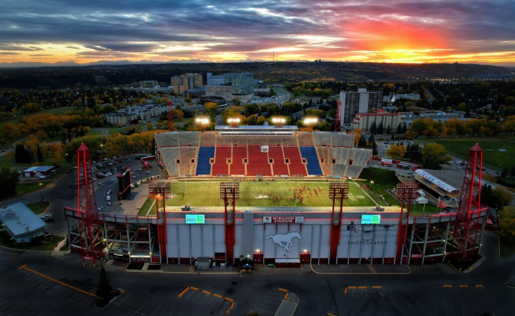 Drone photo of McMahon Stadium in Calgary lit up during evening football match.