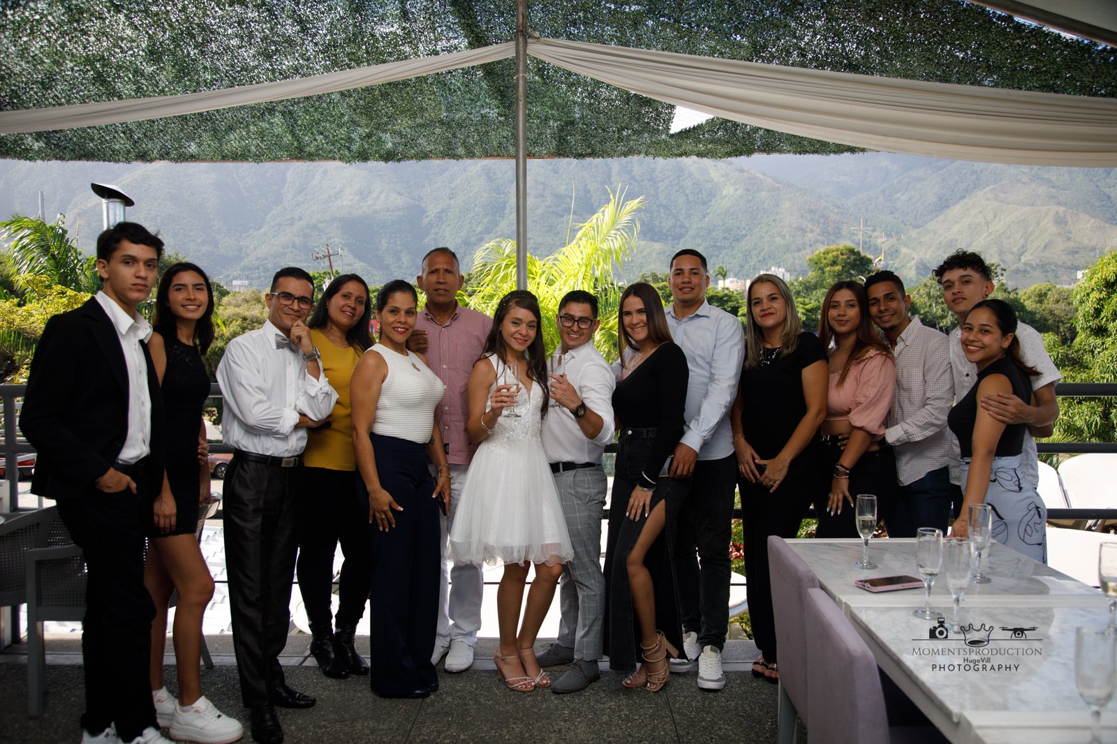 Group photo of people at an outdoor celebration with scenic mountain backdrop